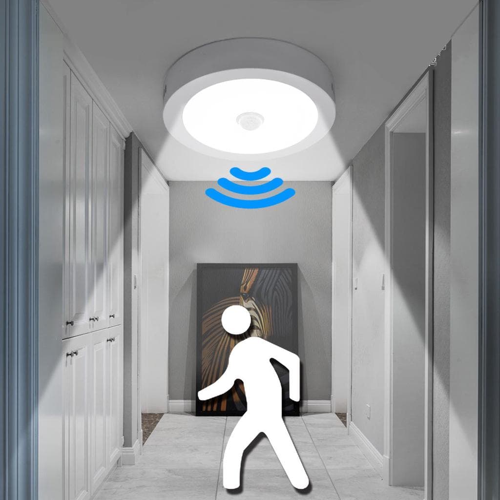 An illustration of a ceiling-mounted motion sensor light in a hallway, detecting a person walking beneath it