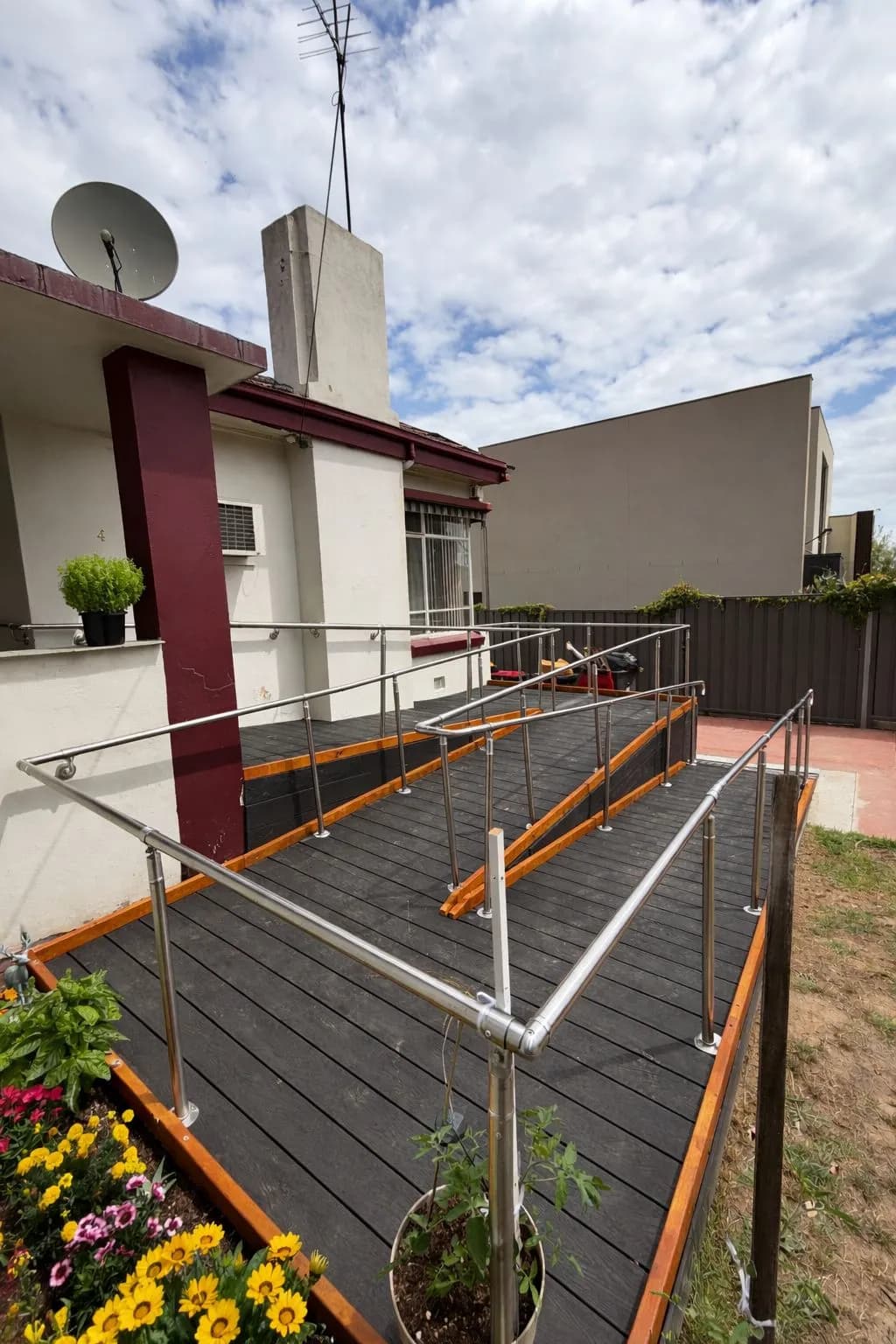 A modular ramp with a composite deck surface and steel handrails turning through a landing