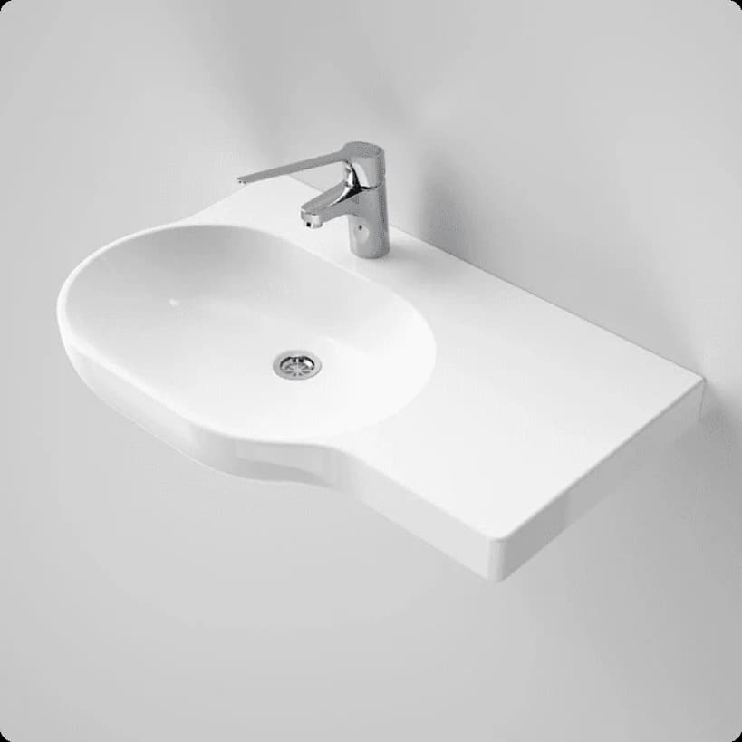 A white wheelchair-accessible wall-hung basin with a shelf on the right