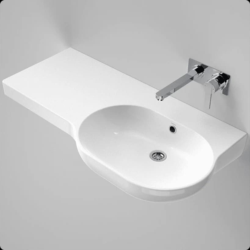 A wide white wheelchair-accessible basin with a wall mixer and a shelf on the left