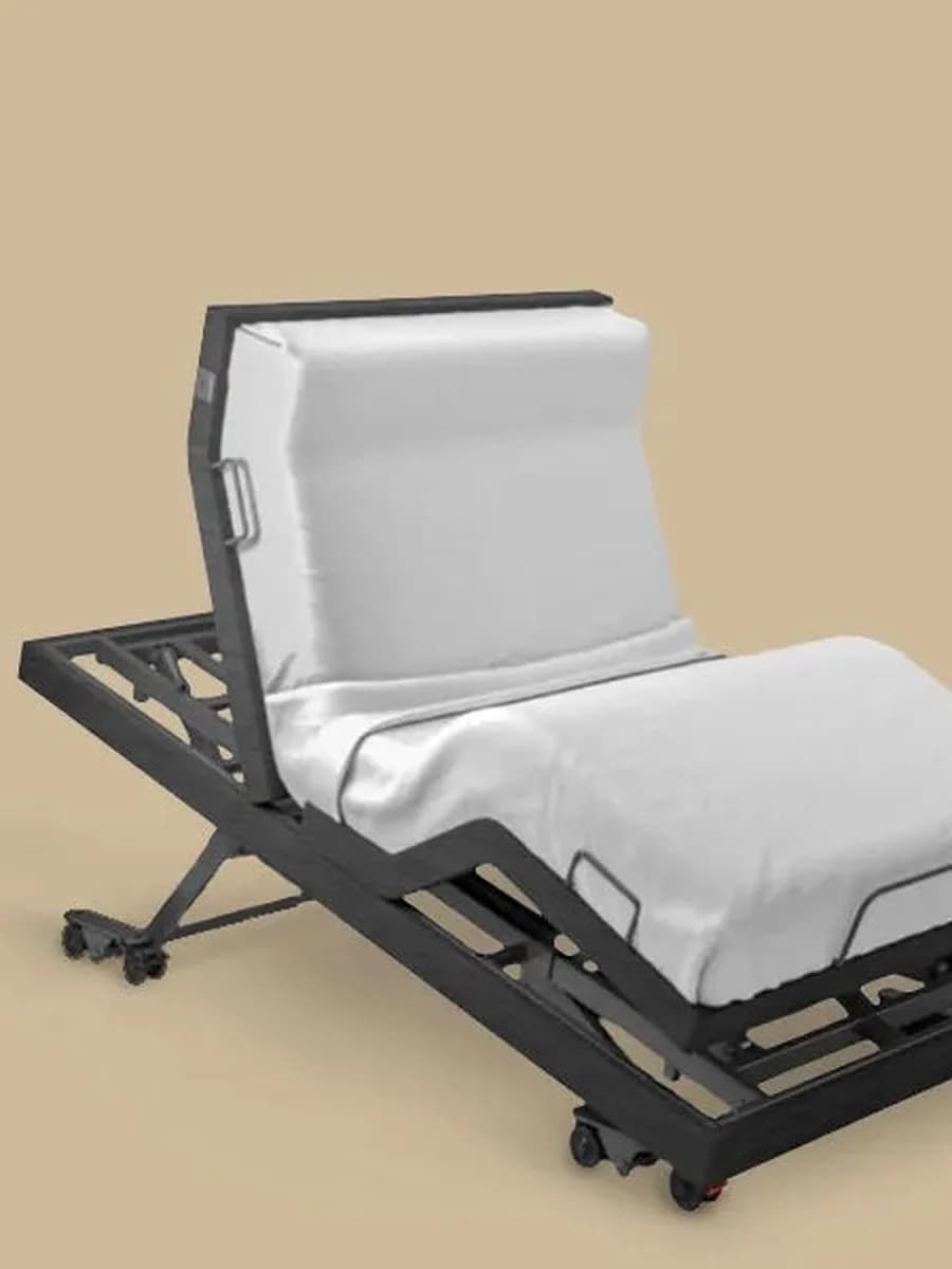 An adjustable homecare bed with the head section raised, on lockable castors