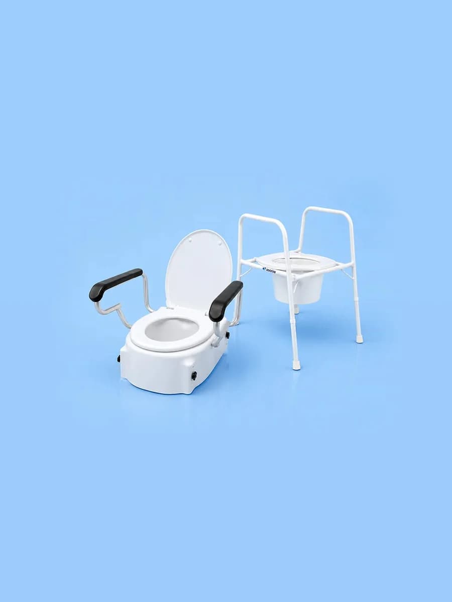 A raised toilet seat with padded armrests beside a freestanding toilet frame