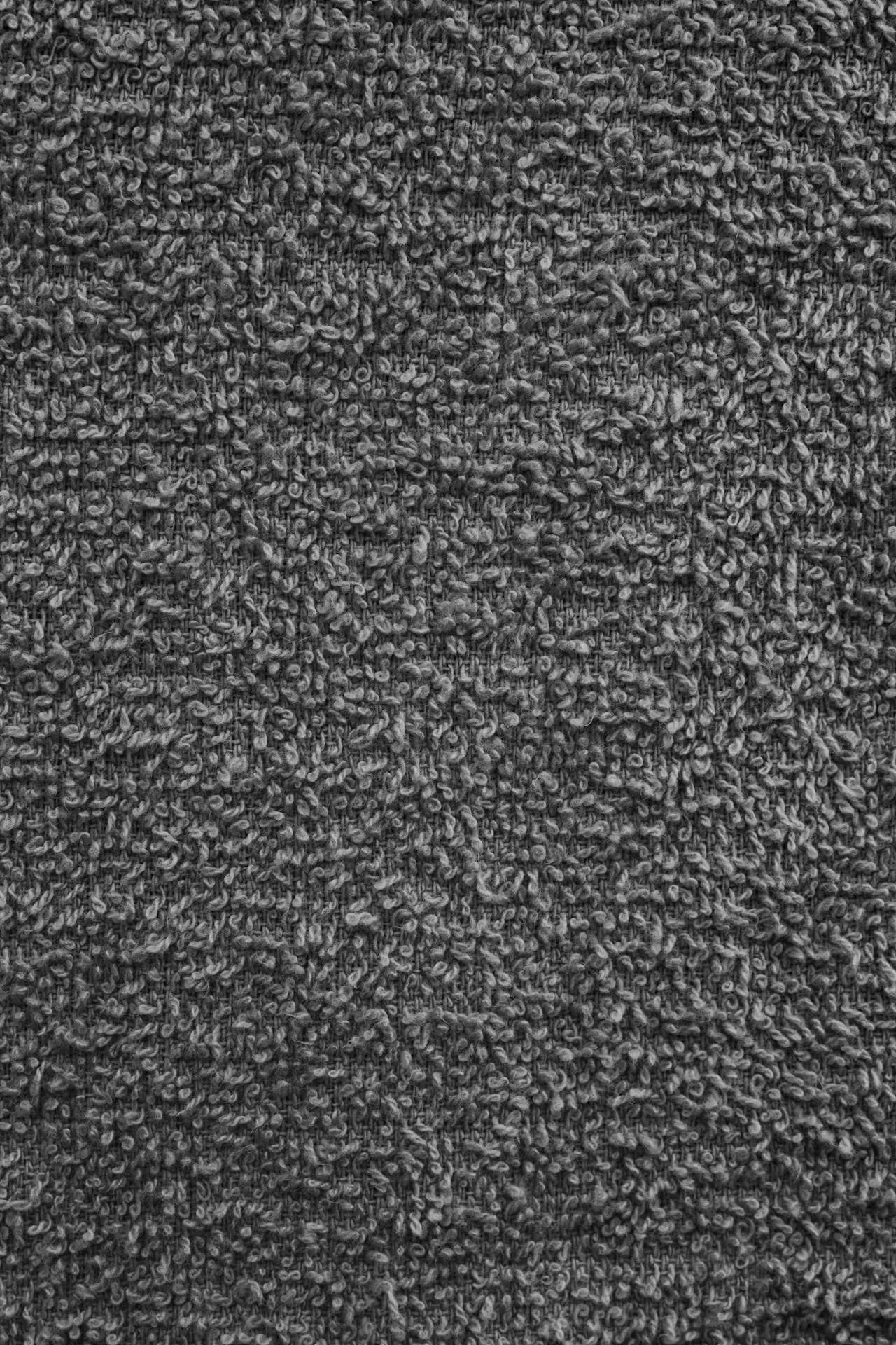 A dense charcoal cut-pile carpet, photographed close up