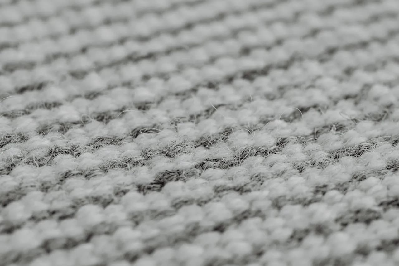 A textured light grey carpet with a fine ribbed weave