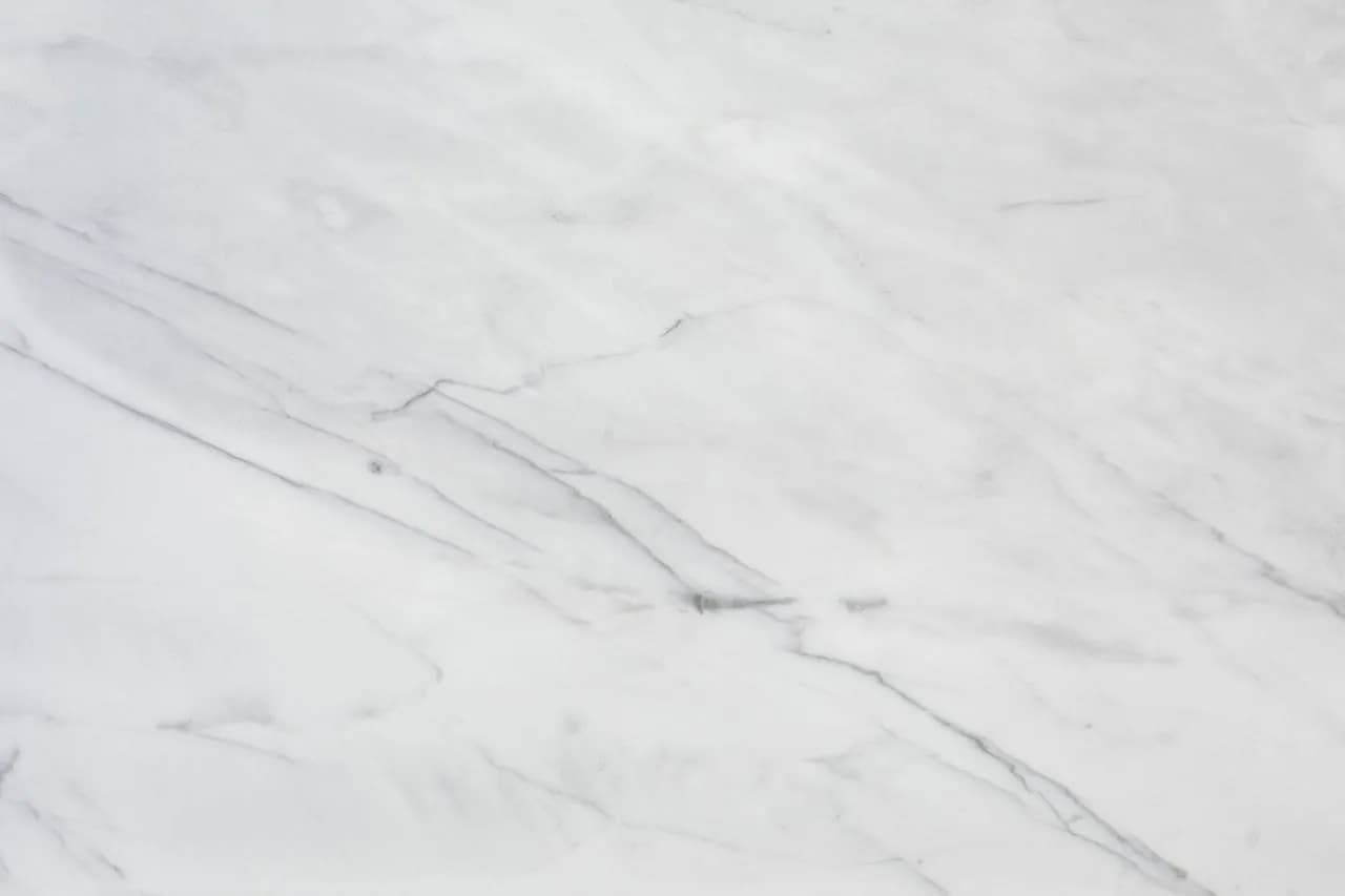A white marble floor tile with soft grey veining
