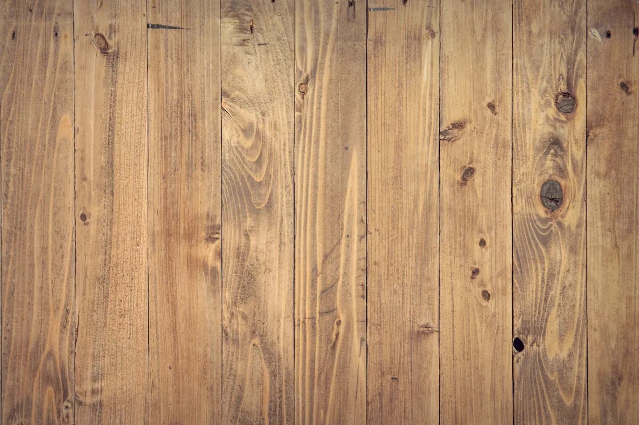 Wide rustic timber floorboards with visible knots and a warm brown finish