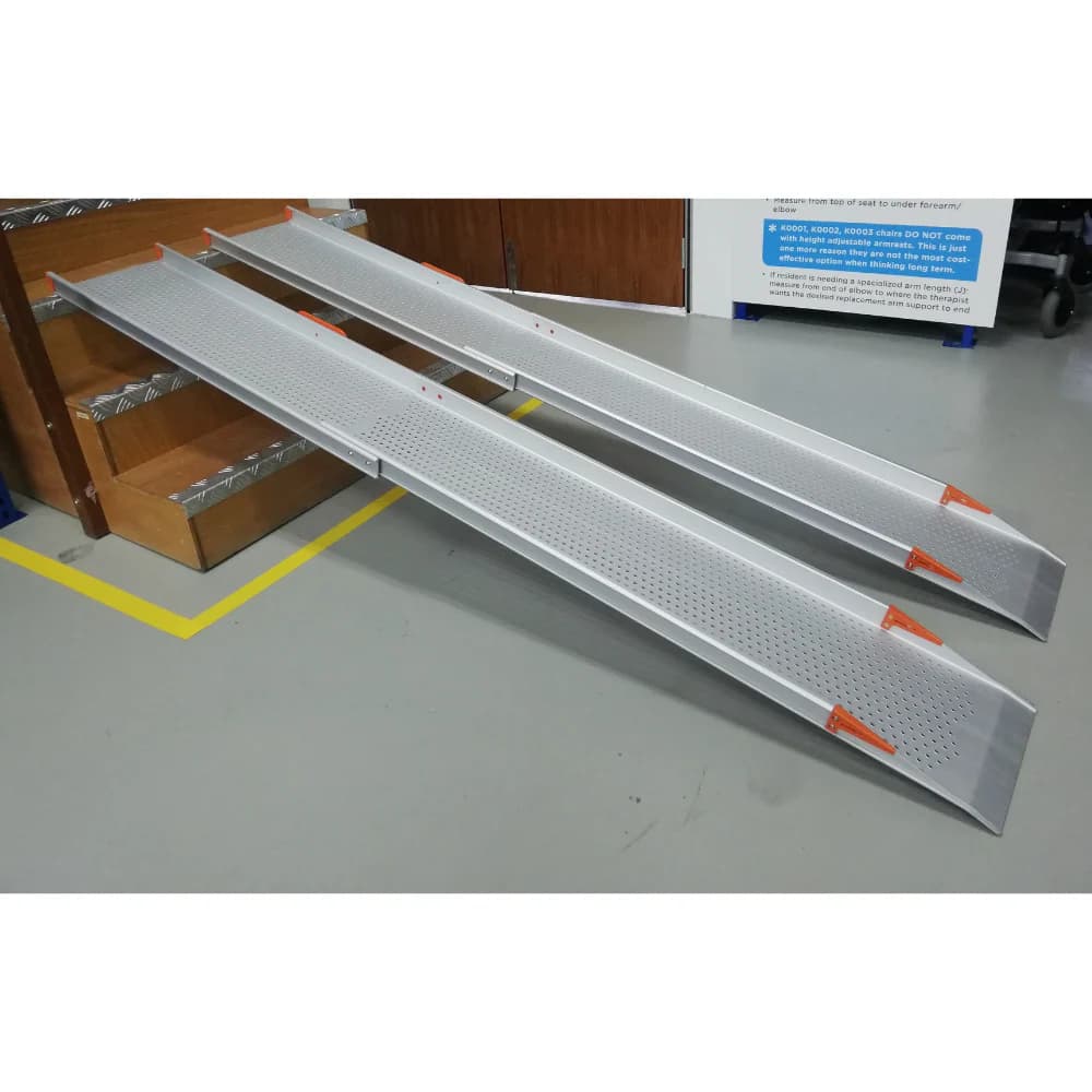 A pair of telescopic aluminium channel ramps with orange end markers, extended side by side