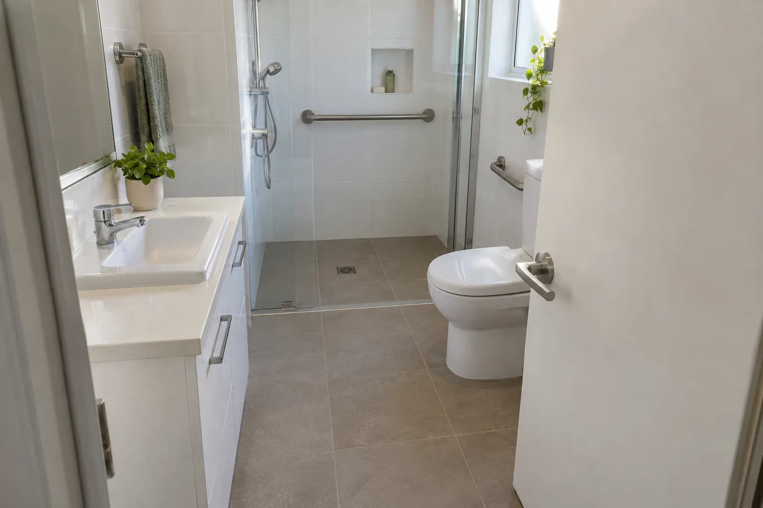 A compact ensuite seen past an inward-opening door that swings into the floor space by the toilet