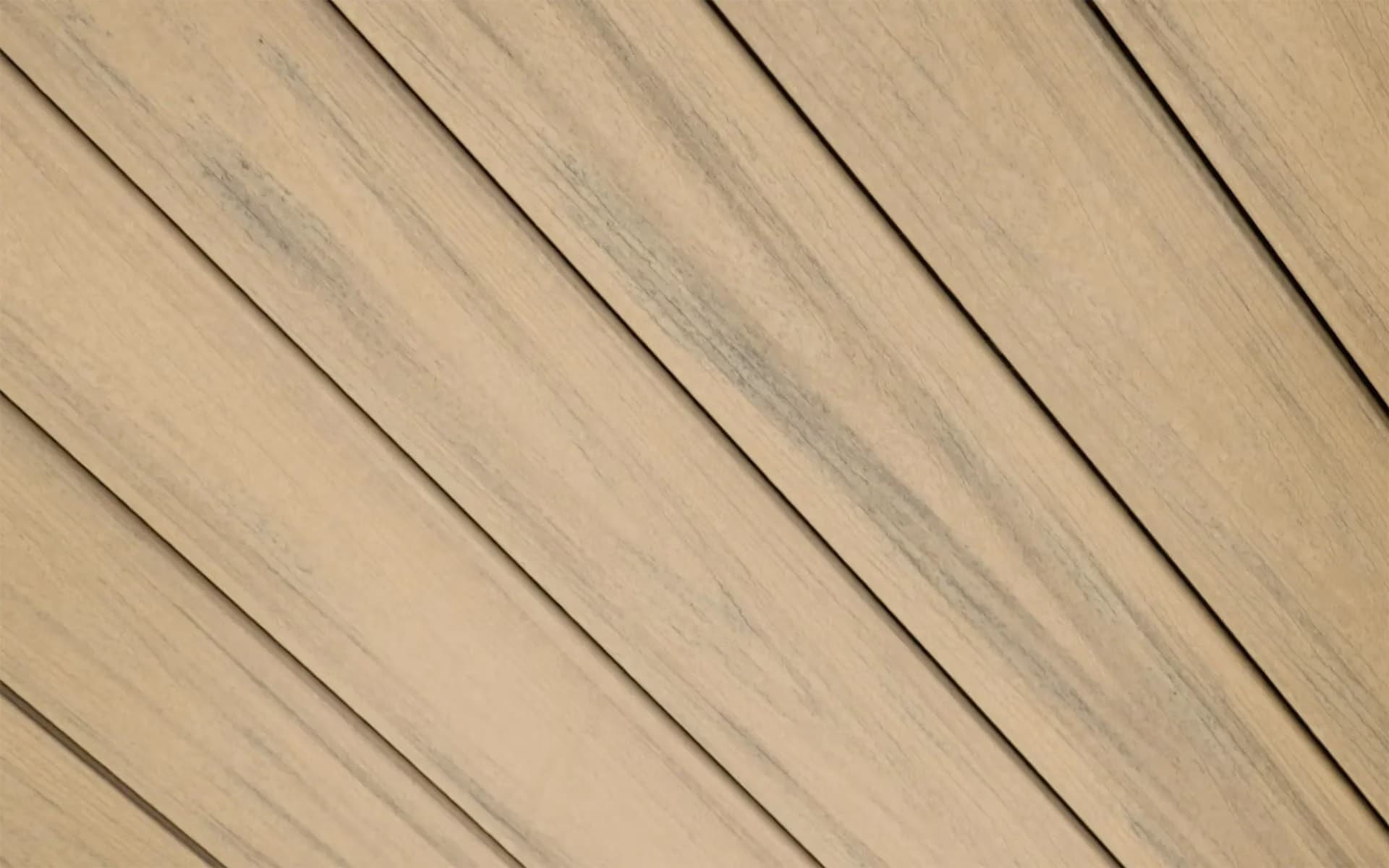 Composite decking boards in a light natural timber tone, laid diagonally