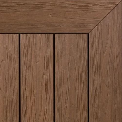 Composite decking boards in a mid-brown walnut tone with a fine woodgrain texture