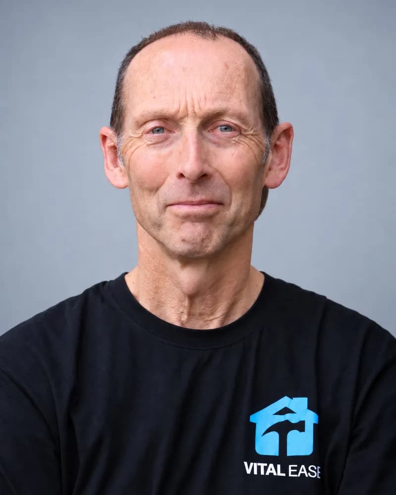 A Vital Ease team member with short grey hair, in a black branded T-shirt