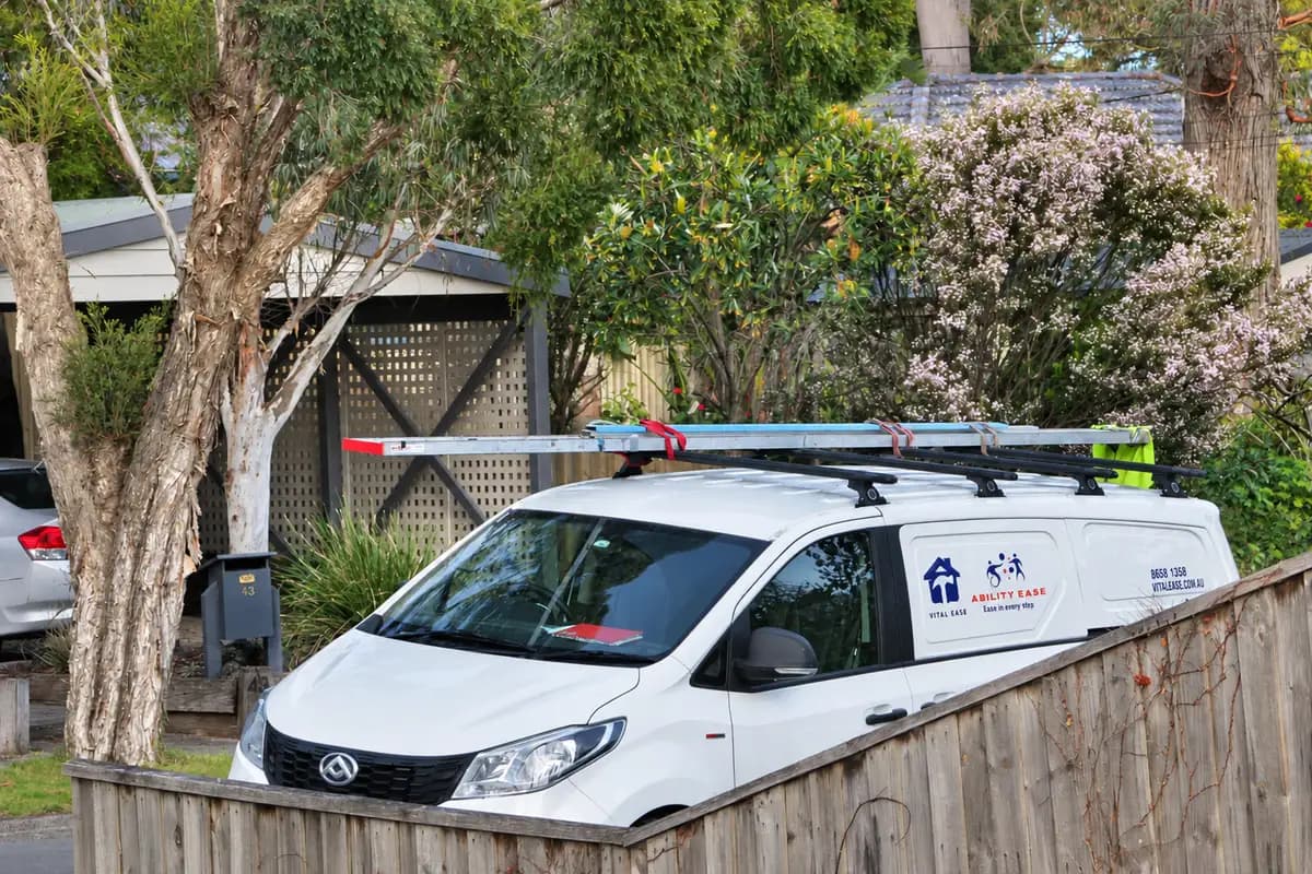The Vital Ease van parked at a suburban house with aluminium ladders strapped to its roof racks